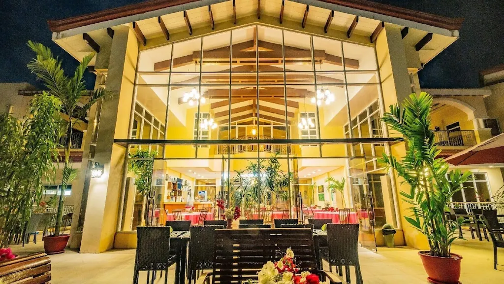 The Palacio at night, lit from inside, its tall glass front open onto laid tables.